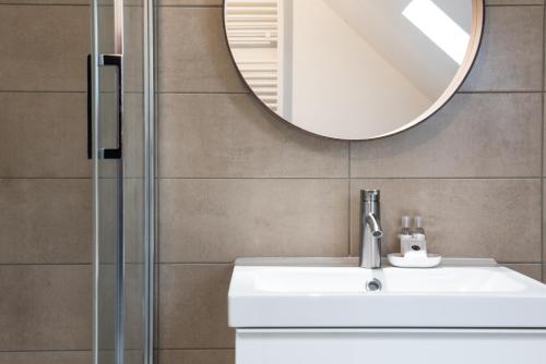 a bathroom with a sink and a mirror at Auguste, La Romaine et My César - Location Saverne in Saverne