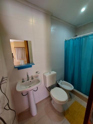 a bathroom with a toilet and a sink and a mirror at Hotel Azul Marino in Santa Teresita