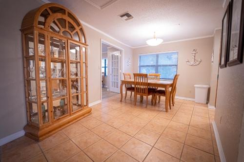 a dining room with a table and a china cabinet at Dockside Inn & Resort in Fort Pierce