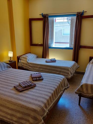 a hotel room with two beds with towels on them at Hotel Azul Marino in Santa Teresita