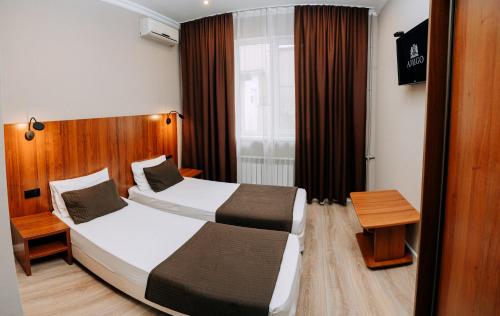 een hotelkamer met 2 bedden en een raam bij AMIGO Tuapse in Toeapse
