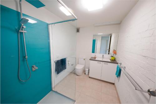 a bathroom with a shower and a toilet and a sink at Max's Beachside Holiday Home in Torquay