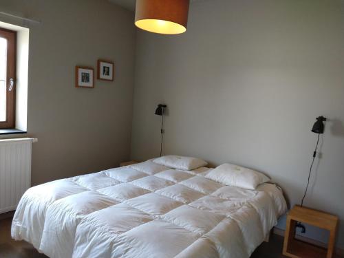 a bedroom with a large white bed in a room at Ardennature vakantiehuizen met privé-sauna in La Roche-en-Ardenne