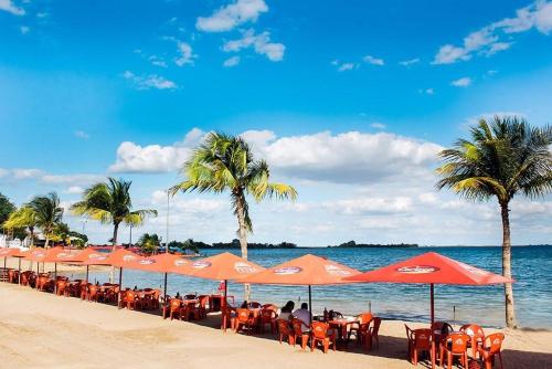 een rij oranje parasols en stoelen op een strand bij Apartamento mobiliado no centro de paulo afonso in Paulo Afonso