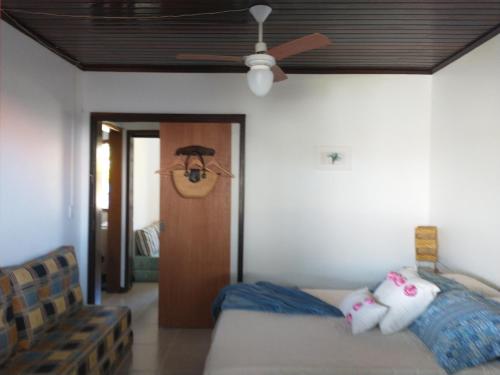 a living room with a ceiling fan and a couch at Casa de veraneio Lar doce mar in Capão da Canoa