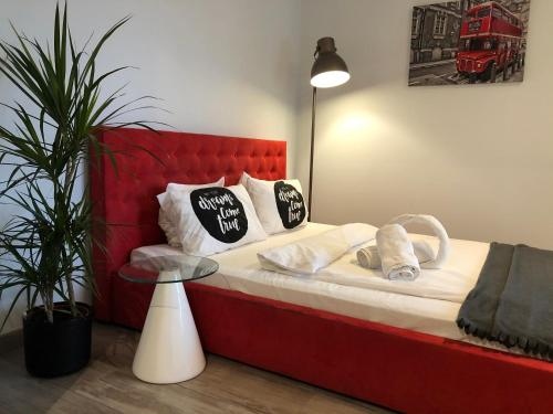 a red bed with pillows on it in a room at Airport Apartment Warszawa in Warsaw