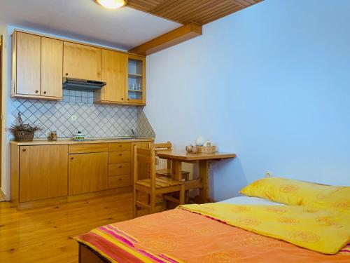 eine Küche mit einem Bett und einem Tisch in einem Zimmer in der Unterkunft Farm Stay Oblak in Rigelj pri Ortneku