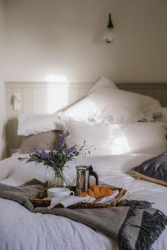 a tray of food and flowers on a bed at Elm Tree Cottage in Fivemiletown