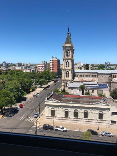 a large building with a clock tower in a city at Apartamento Bela Vista in Uruguaiana