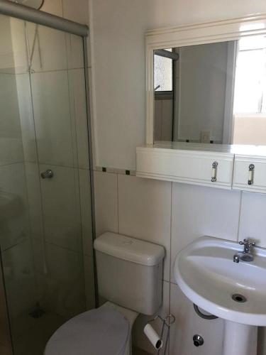 a bathroom with a toilet and a sink and a mirror at Apartamento Bela Vista in Uruguaiana