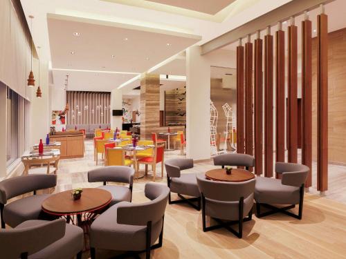 a lobby with tables and chairs and a cafeteria at ibis Hyderabad Hitec City - An Accor Brand in Hyderabad