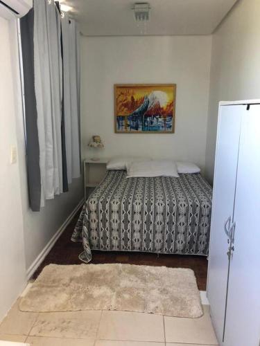 Apartamento Bela Vista في أوروغويانا: غرفة نوم بسرير ودهان على الحائط
