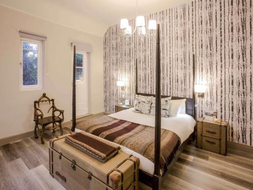 a bedroom with a large bed with a large canopy at Hunton Park Hotel in Kings Langley