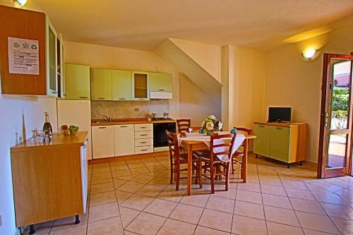 a kitchen and dining room with a table and chairs at Residence Stella Marina in San Teodoro