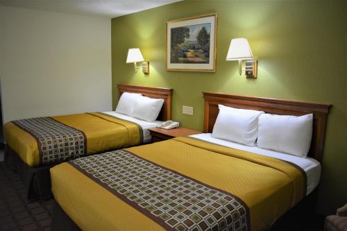 a hotel room with two beds and a phone at Bloomer Inn & Suites in Bloomer