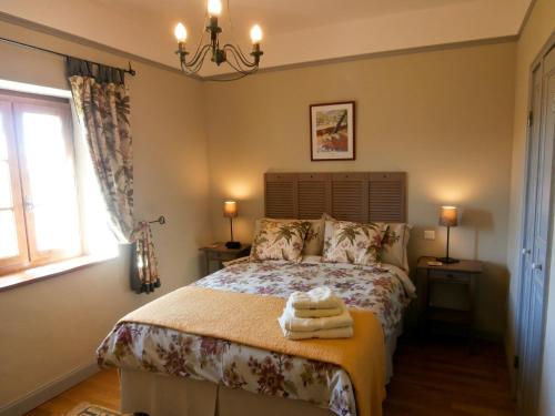 1 dormitorio con 1 cama con toallas en Domaine de Lasfonds en Rieupeyroux