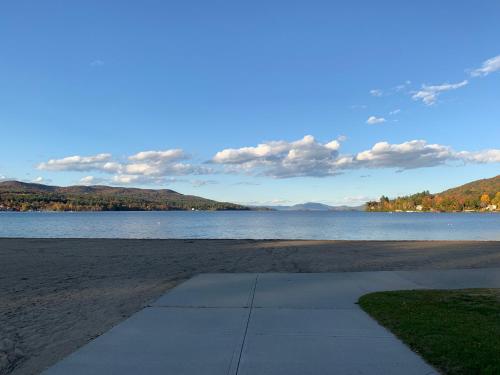 a sidewalk on a beach next to a body of water at Motel Montreal in Lake George