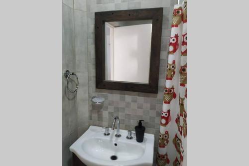 y baño con lavabo y espejo. en Departamentos Calasanz PB 4 en Mar del Plata