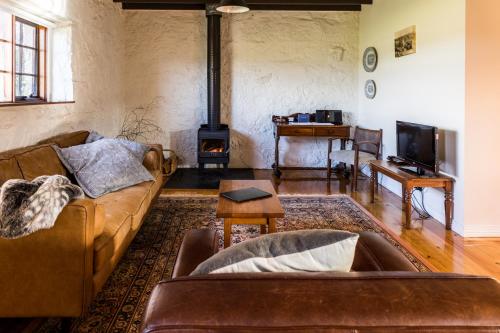 a living room with a couch and a fire place at Daisy Bank Cottages in Richmond