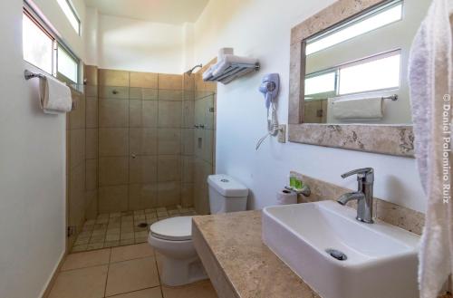 a bathroom with a toilet a sink and a bathtub at Hotel Casa Pridda in Puerto Escondido
