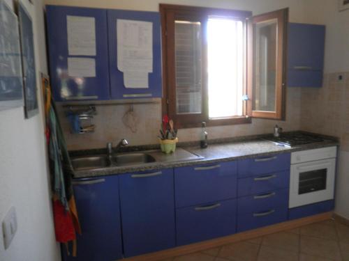 a kitchen with blue cabinets and a sink and a window at Casa Valentina in Santa Lucia