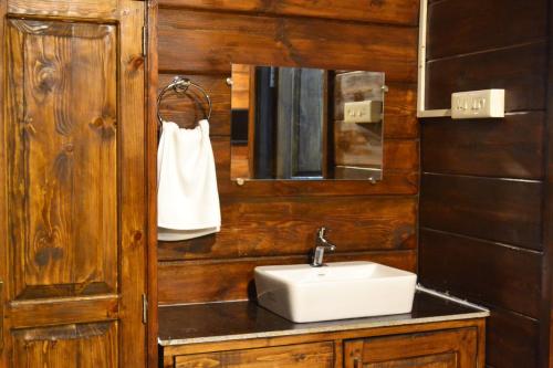 ein Bad mit einem Waschbecken und einem Spiegel in der Unterkunft Radhika Eco Resort(Odonata) in Arambol