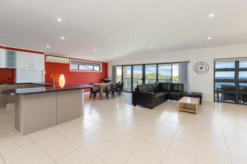 a kitchen and living room with a couch and a table at Burgess Beach 1 in Forster