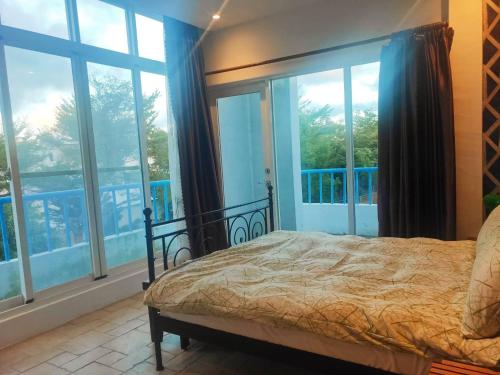 a bedroom with a bed and large windows at Oia Cafe B&B in Taitung City