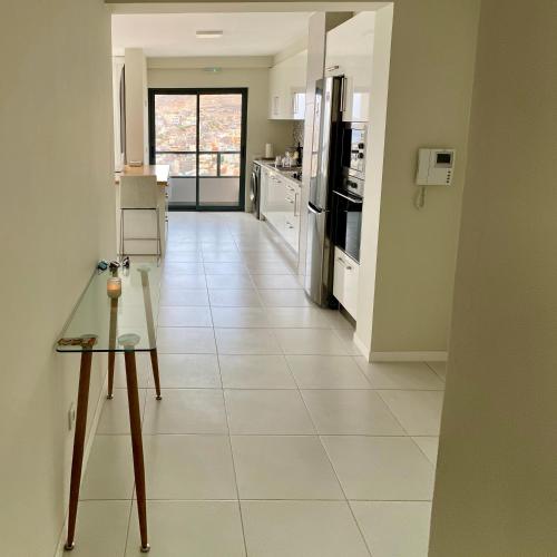 a kitchen with white tile flooring and a table in a room at Ocean View Stay in Mindelo
