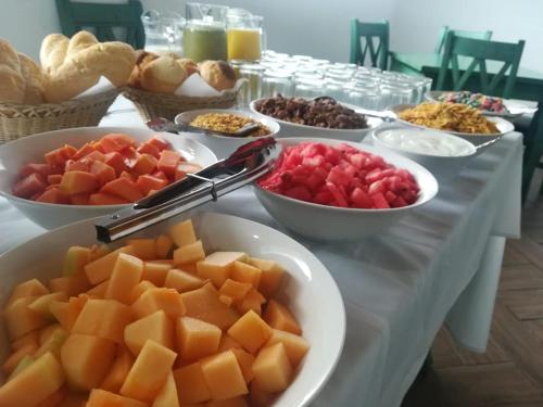 a table topped with bowls of fruit and plates of food at Hotel Vintage "Rialto" in Quetzaltenango