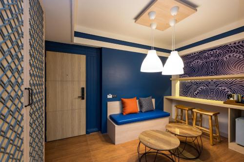 a room with blue walls and a table and chairs at Maldives Beach Resort in Chao Lao Beach