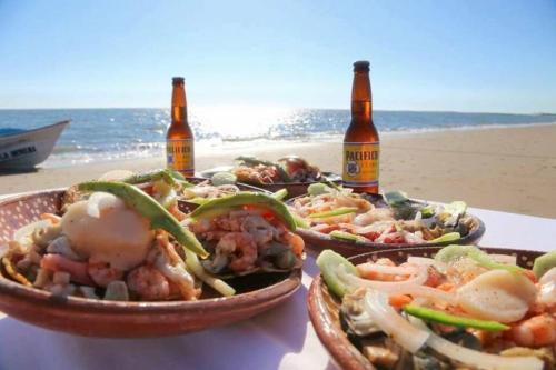 two baskets of food and two bottles of beer on the beach at Departamento para familias in Mazatlán