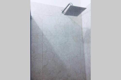 een douche met een glazen deur en een douchekop bij Departamento para familias in Mazatlán