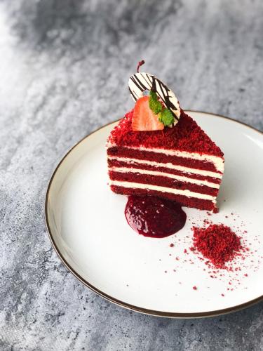 a piece of red velvet cake on a plate at GRAMM HOTEL by Ambarrukmo Yogyakarta in Yogyakarta