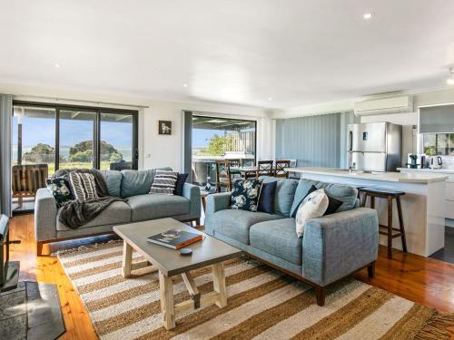 a living room with two couches and a kitchen at Gokus Shack Rural and water views with a spa in Corinella