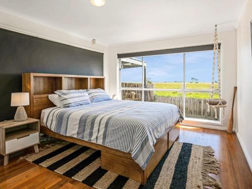 CorinellaにあるGokus Shack Rural and water views with a spaのベッドルーム1室(ベッド1台、大きな窓付)