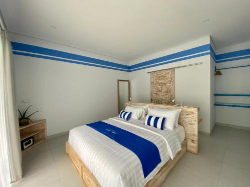 a bedroom with a bed with blue and white stripes at Kura Kura Divers Lodge in Amed