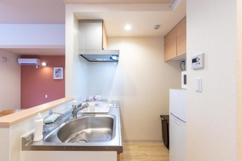 La cuisine est équipée d'un évier et d'un réfrigérateur. dans l'établissement VACATION INN HEIWAJIMA I, à Tokyo