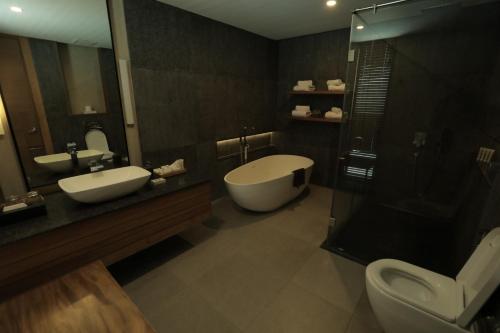 a bathroom with two sinks and a shower and a toilet at Escala Tagaytay in Tagaytay