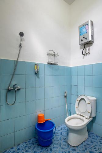 a blue bathroom with a toilet and a shower at Prananto's Villa in Lembang