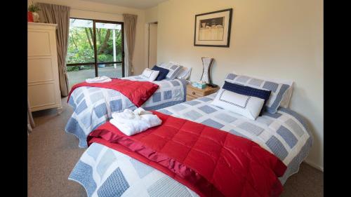 two twin beds in a room with a window at Bellbird Guest Accommodation in Akaroa