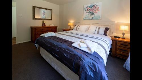a bedroom with a large bed with towels on it at Bellbird Guest Accommodation in Akaroa