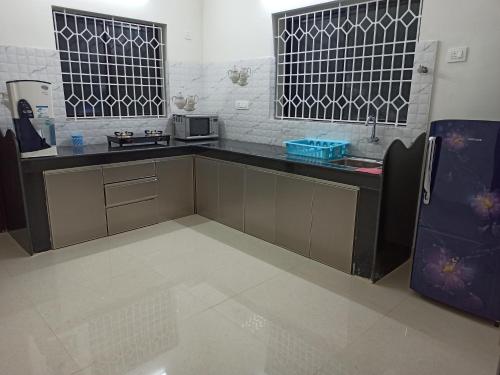 a kitchen with a black counter and a microwave at VENUS HOMES in Mangalore