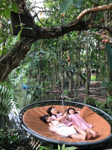 a group of people laying in a hammock in a tree at Saigon Garden Homestay in Ho Chi Minh City