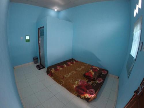 a small bedroom with a bed in a blue room at Penginapan asidik in Bira