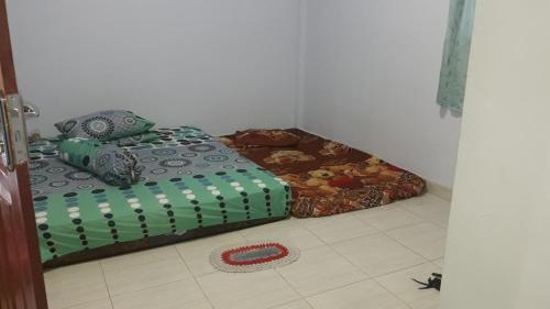 a room with a bed with a green at Penginapan asidik in Bira