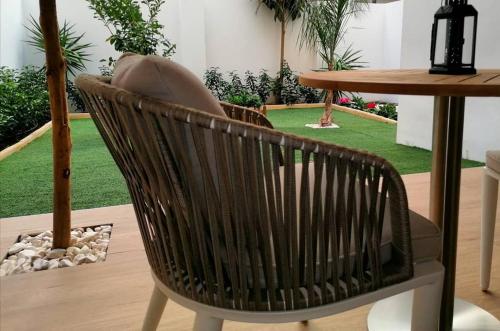 a brown chair sitting next to a table and a table and grass at Lux Suite in Taranto