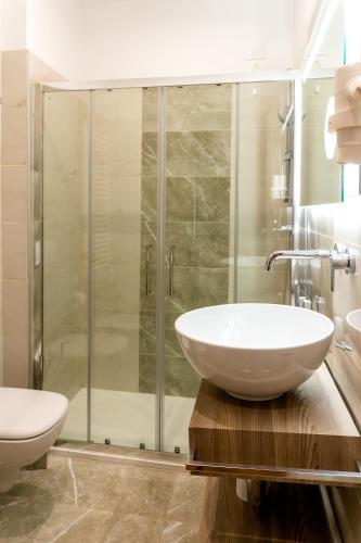 a bathroom with a sink and a glass shower at Hotel Victoria in Cuneo