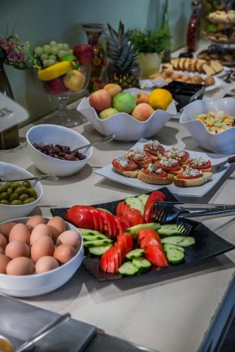 a table topped with plates of food and bowls of fruit at ASTRA Village Resort in Svoronata