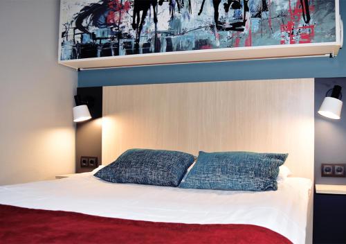 um quarto com uma cama com duas almofadas azuis em Good Morning Mölndal em Mölndal